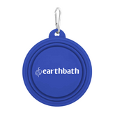 A blue collapsible silicone pet bowl with a carabiner attached to it, branded with 'earthbath'.